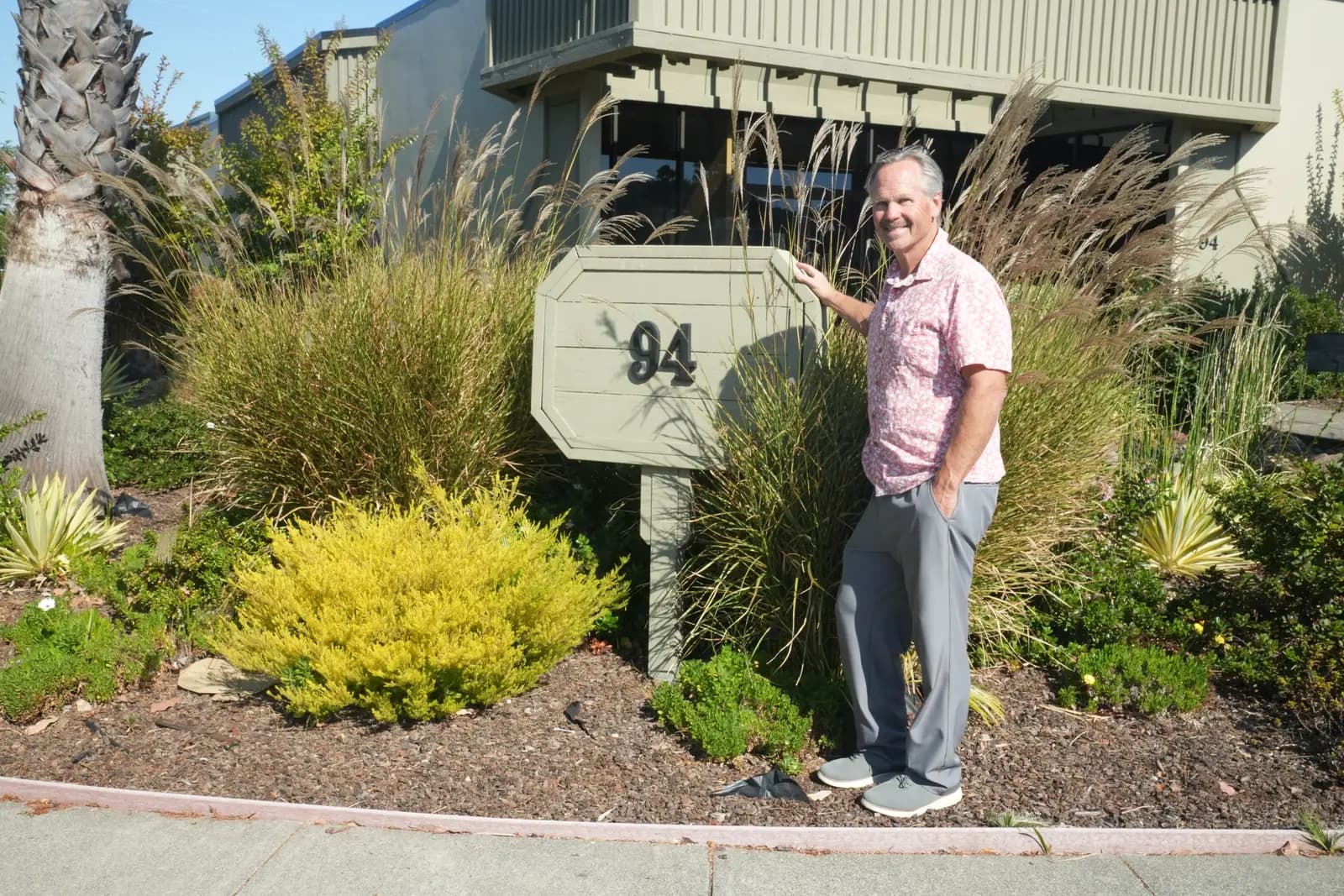 George Simmons beside the 94 Galli Drive address sign outside the shop in Novato