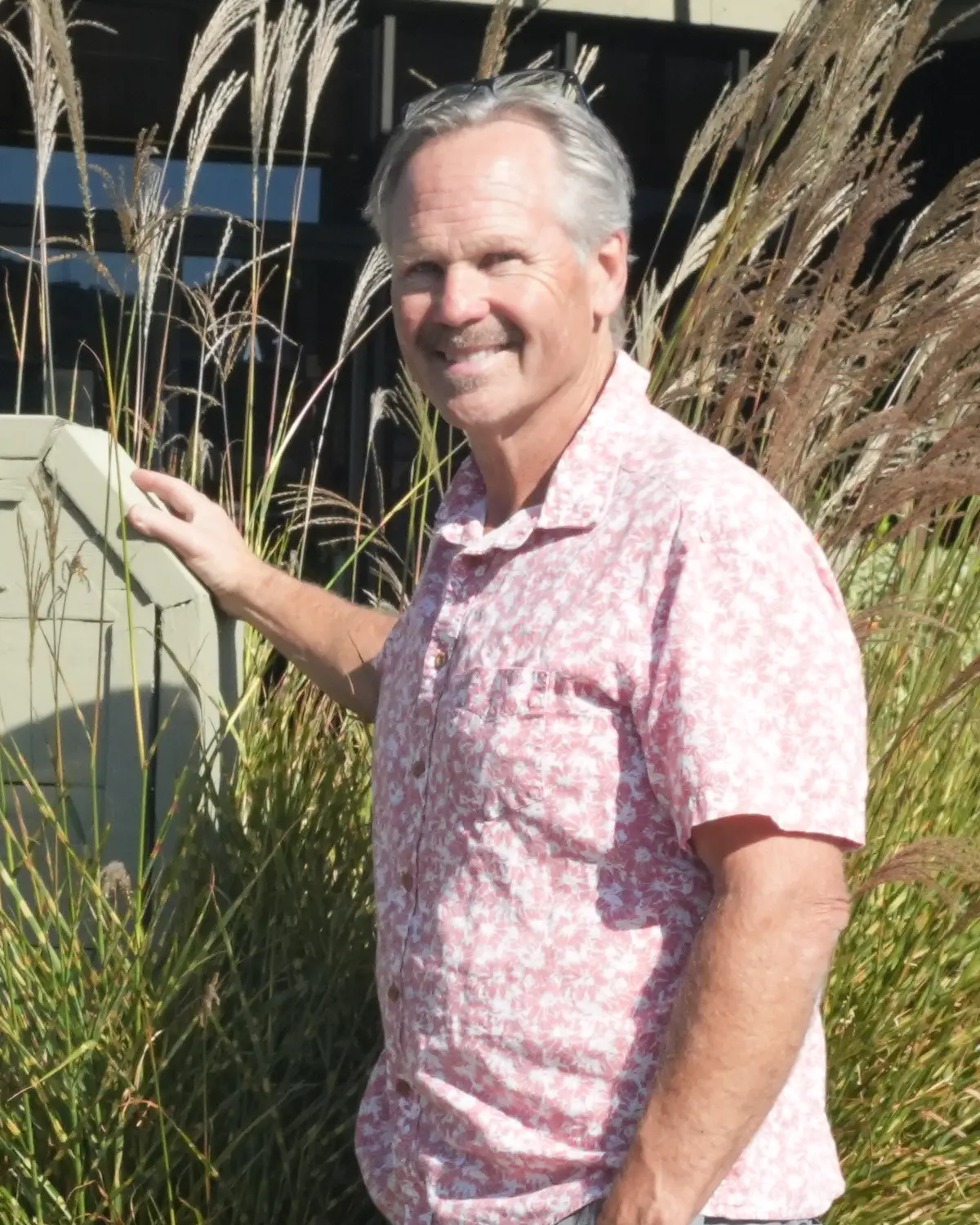 George Simmons smiling outside the GMS Lazerworks shop at 94 Galli Drive in Novato