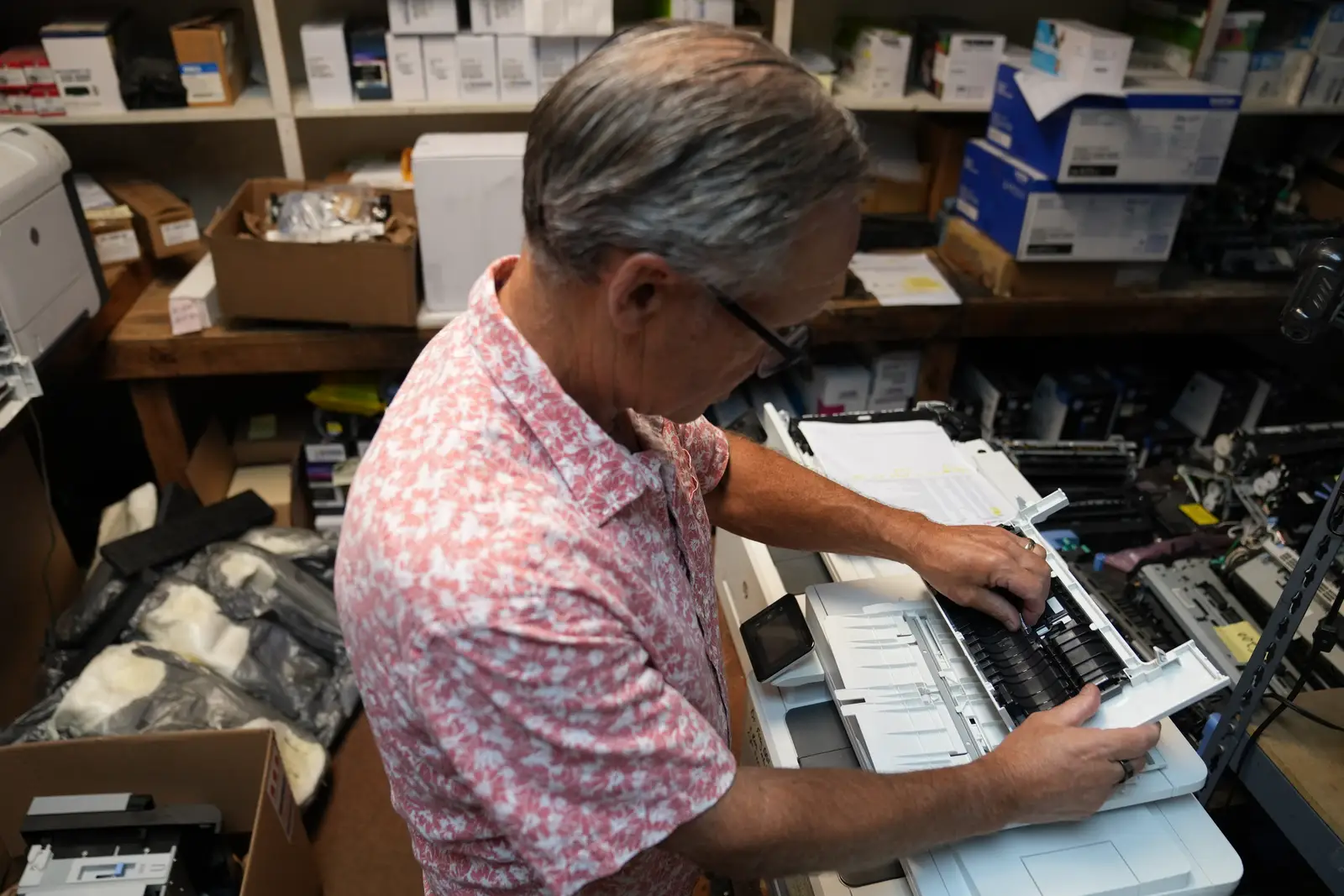 George Simmons adjusting the document feeder of a scanner on the repair bench