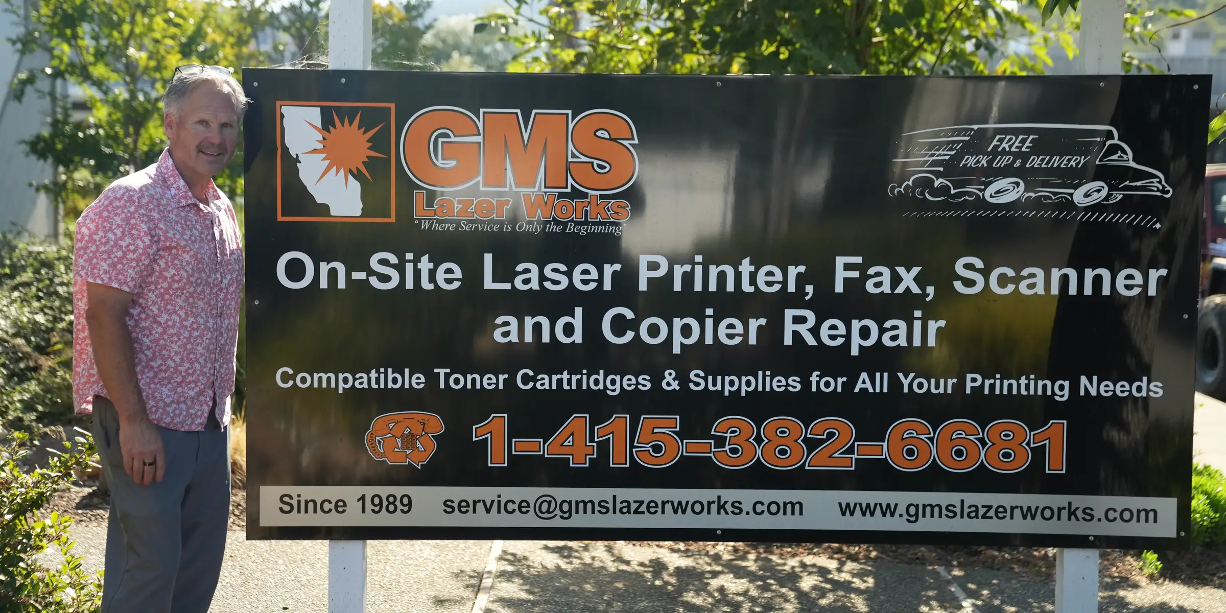 George Simmons standing next to the GMS Lazerworks on-site repair sign outside the Novato shop